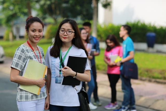 Hai nữ sinh viên Trường Đại học Quốc tế IU cầm tập tài liệu trong khuôn viên trường