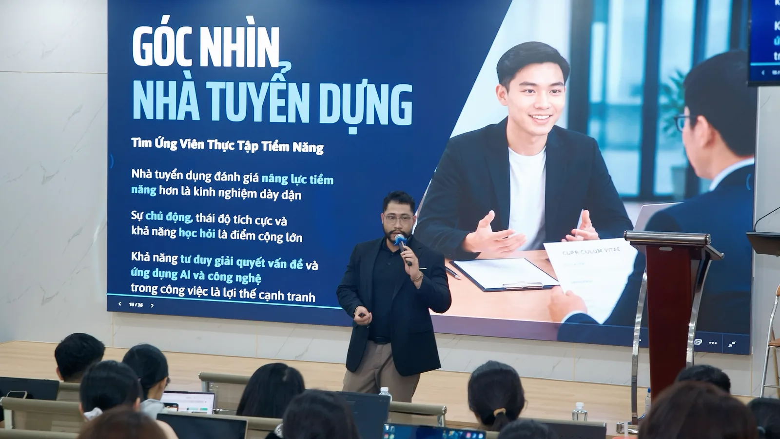 Anh Lê Châu Bá đứng chia sẻ trước màn hình trình chiếu “Góc nhìn nhà tuyển dụng”