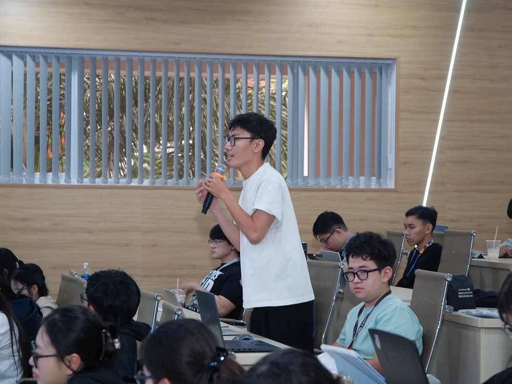 Một sinh viên đứng lên cầm micro đặt câu hỏi cho diễn giả