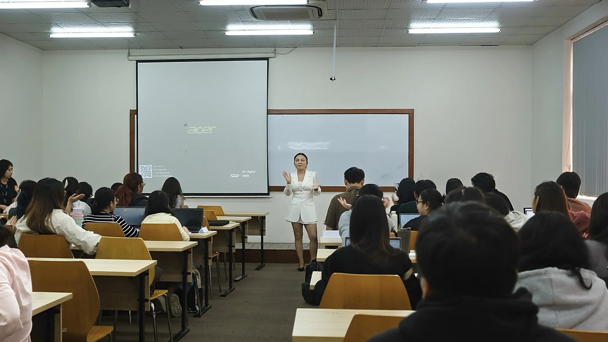 Chị Nancy Lê đứng trước lớp BA275IU, sinh viên ngồi kín các dãy bàn